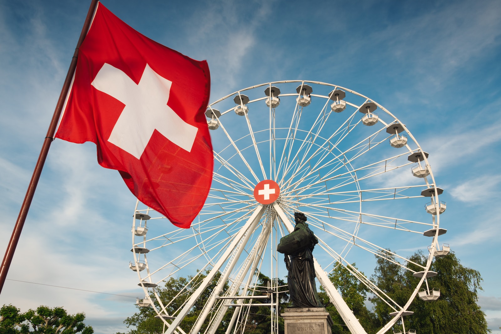 une grande roue à côté d'une statue